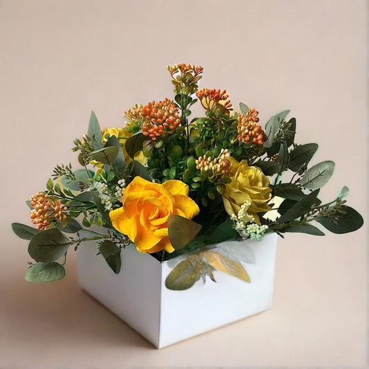 A lovely white box arrangement of gorgeous yellow/orange roses mixed with artificial green foliage.  A lovely, thoughtful gift for anyone.  Size: H30 x W40cm  This piece is available with other flowers or custom shades, please contact us for a custom/bespoke quote.
