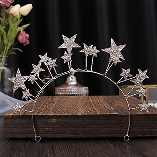 The Stars Tiara is delightful and whimsical, a tiara for the young and the young at heart. The stars (8 x small, 7 x medium, 3 x Large) are of white stones set in silver metal, and stands up proudly from the band.  Colour:  Silver  Pattern:  Stars  Size:  W6.5cmxDiamter14cm  Weight: 71g