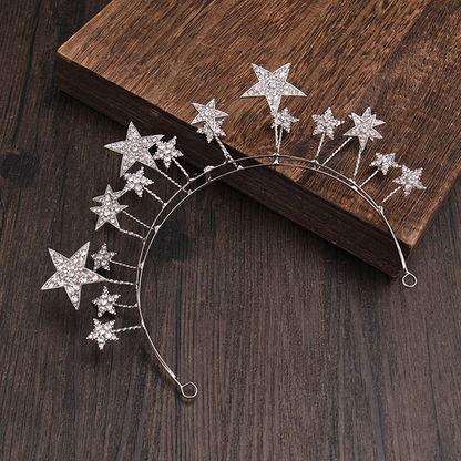 The Stars Tiara is delightful and whimsical, a tiara for the young and the young at heart. The stars (8 x small, 7 x medium, 3 x Large) are of white stones set in silver metal, and stands up proudly from the band. Colour: Silver Pattern: Stars 