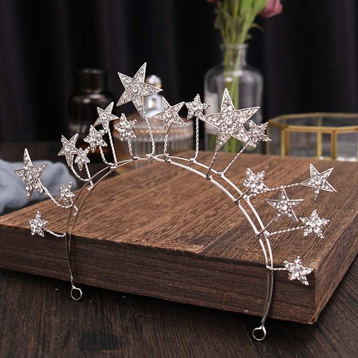 The Stars Tiara is delightful and whimsical, a tiara for the young and the young at heart. The stars (8 x small, 7 x medium, 3 x Large) are of white stones set in silver metal, and stands up proudly from the band.  Colour:  Silver  Pattern:  Stars  Size:  W6.5cmxDiamter14cm  Weight: 71g