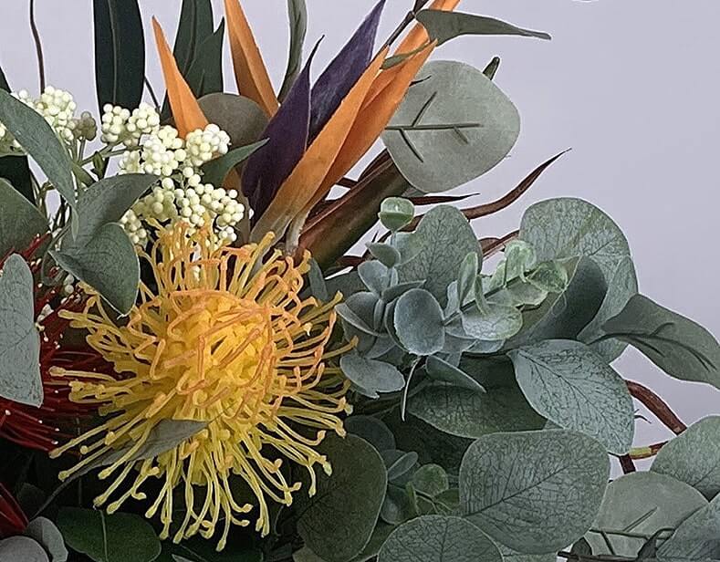 Beautiful artificial flower bouquet includes Pohutukawa, spider chrysanthemums, eucalyptus leaves, bird of paradise, and leucospermum. The stunning oranges and reds give this bouquet its exotic look, and very much a Kiwi feel. Atelier Blooms Auckland