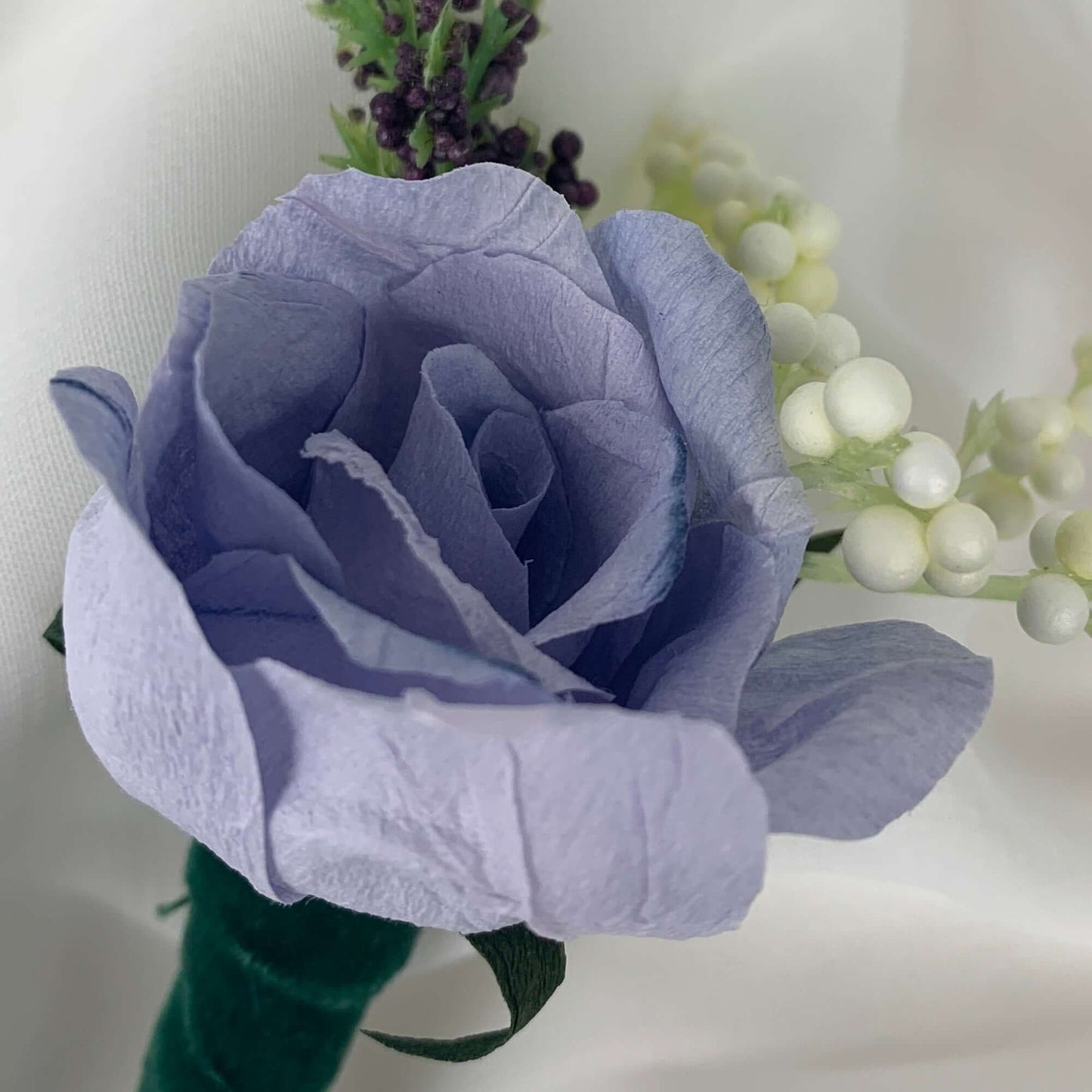 A beautiful hand-crafted paper (faux) large mauve rose boutonnieres, with a green satin stem, mixed with artificial flowers and foliage, are made to order to match your wedding theme colour and are perfect for the groom, the groomsmen, and fathers for you