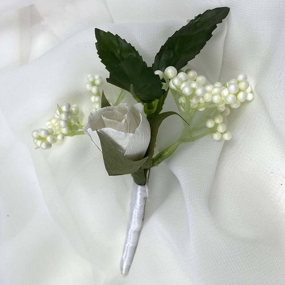 A beautiful hand-crafted paper (faux) white rosebud boutonnieres, with a white satin stem, mixed with artificial flowers and foliage, are made to order to match your wedding theme colour and are perfect for the groom, the groomsmen, and fathers for your special occasion. Atelier Blooms