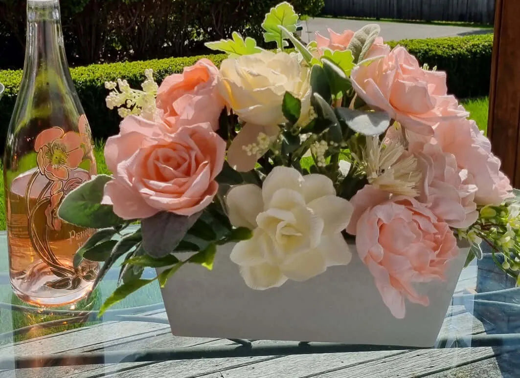 Gorgeous roses, peonies and chrysanthemums with pale shades of Ivory and peach mixed with green foliage.  This stunning arrangement will add beautiful colour to your decor and bring a little spring/summer into your home or office.  This piece is available with other flowers or custom shades, please contact us  for a custom/bespoke quote.  Size:  W37 x H22 x D25cm  IMAGE SHOWING WITH BOTTLE WINE