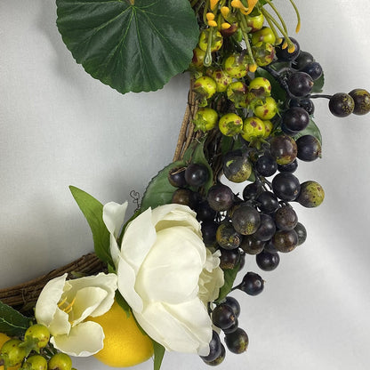 Our Lemon Wreath is a fresh take on the traditional and offers bright sunny lemons with white flowers and black and green berries with white peonies and yellow spider chrysanthemums, tied up with a hessian bow.   Size: 36cm outer/23cm inner diameter