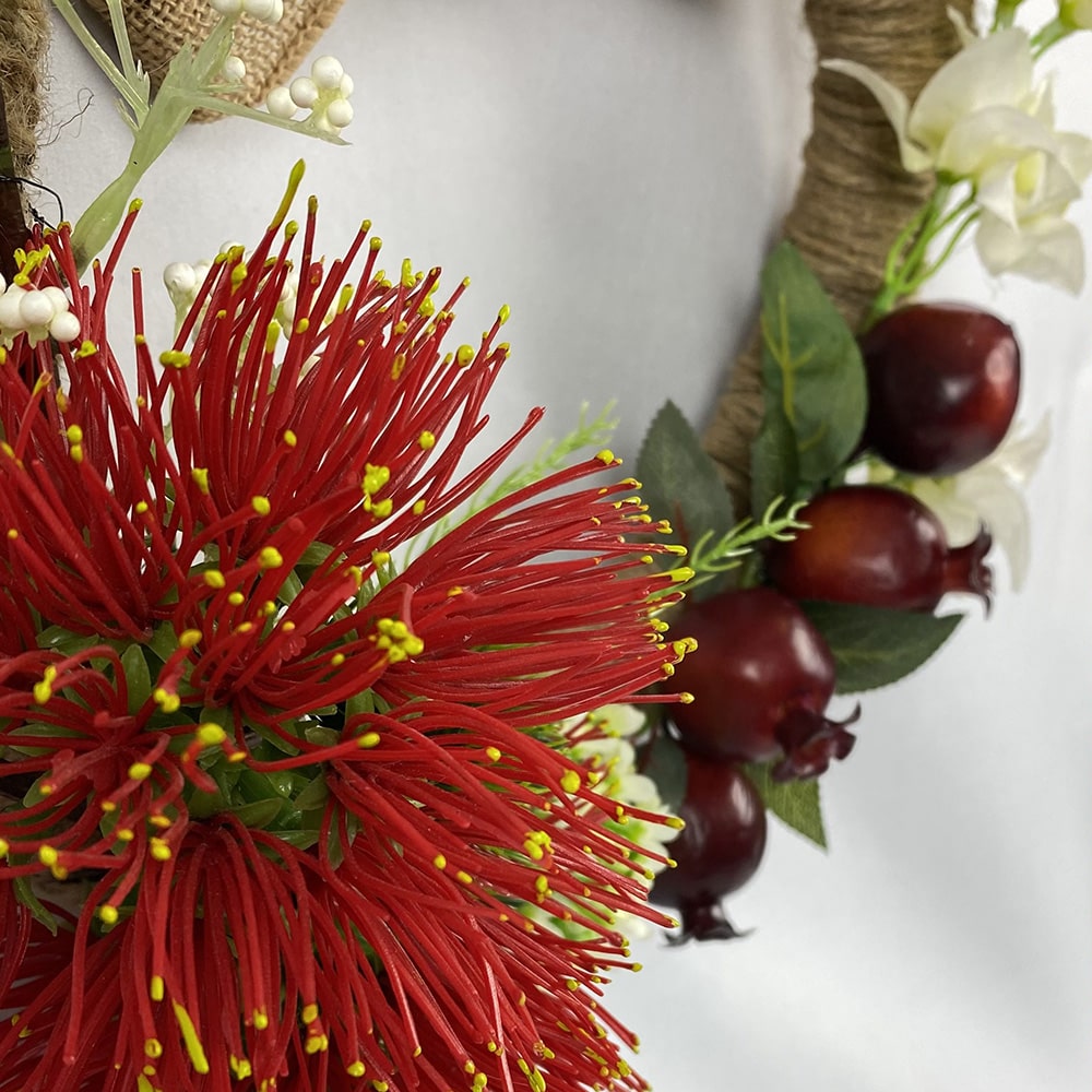 Our gorgeous Pomegranate and Pohutukawa Wreath is rich in colour and texture with white wax flowers, bougainvillea and foam berries. Bound in natural twine, a double hessian bow completes our wreath.  Size:  36cm outer/21cm inner diameter