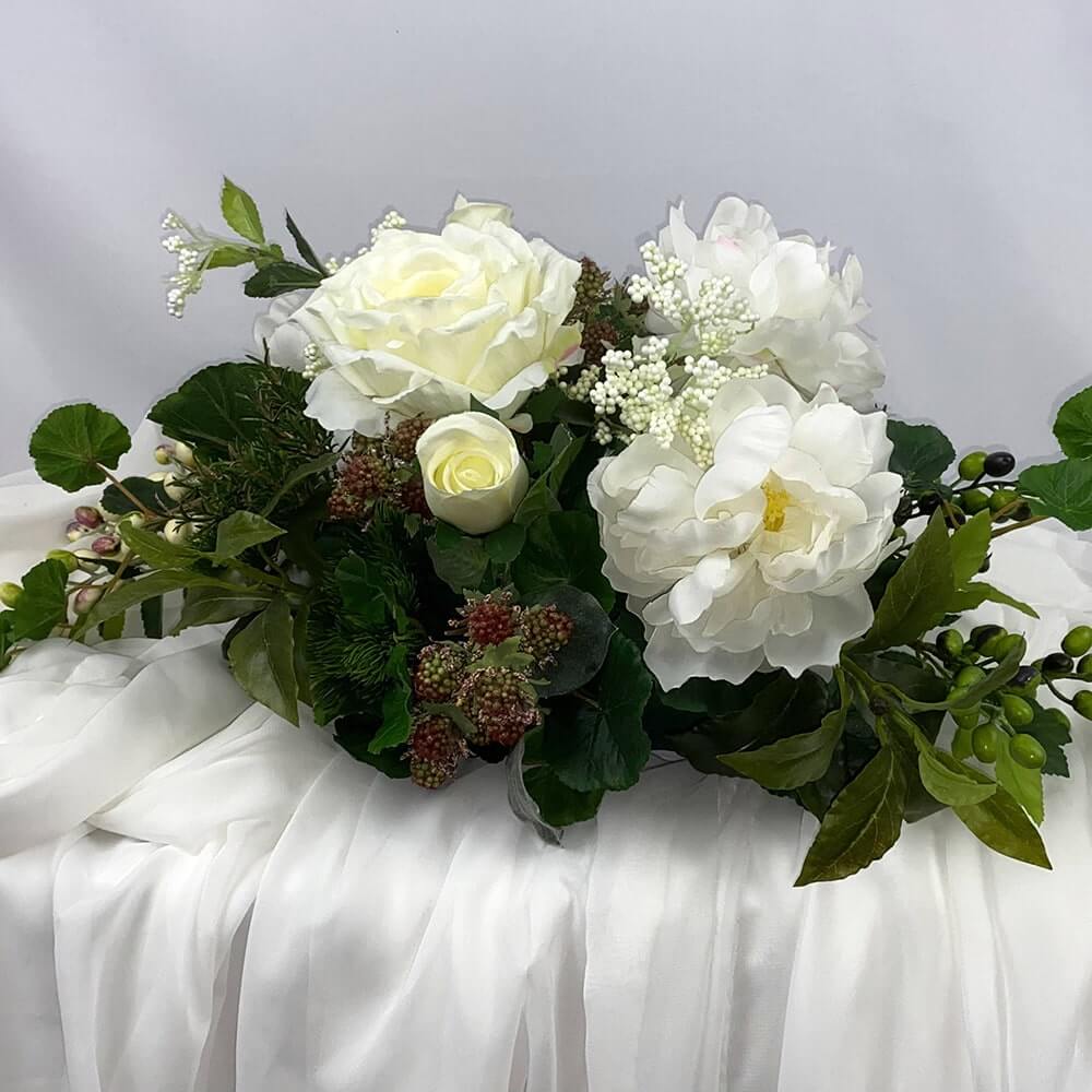 A gorgeous table centre piece of Ivory roses and peonies that will add a special little something to your Christmas day table.   Size:  H23 x L62 x W33cm