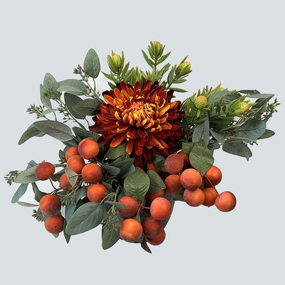 Gorgeous artificial flower arrangement with flaming shades of autumn, consists of a stunning artificial orange Winter Mum Chrysanthemum as the main piece, surrounded by Leucadendron Spray and melon berries in a black dimpled ceramic pot. The arrangement i