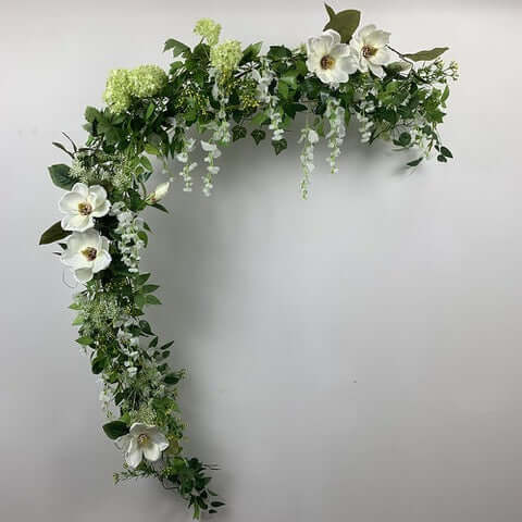 This beautiful garland is a mix of magnolias, snowball hydrangeas, field flowers, Queen Anne lace and mini berry spray. Can be hung anywhere or straightened out to place on your wedding table or fireplace mantle for a backdrop for your wedding photos.  Size:  2 metres  For this bouquet in a different colour, please contact us for a custom quote.