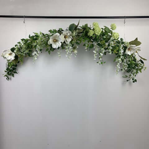 This beautiful garland is a mix of magnolias, snowball hydrangeas, field flowers, Queen Anne lace and mini berry spray. Can be hung anywhere or straightened out to place on your wedding table or fireplace mantle for a backdrop for your wedding photos.  Size:  2 metres  For this bouquet in a different colour, please contact us for a custom quote.